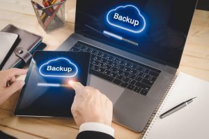 Businessman backup data from laptop and tablet device to cloud service