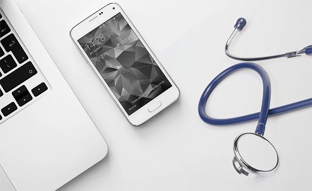 an image with stethoscope,phone and laptop on desk
